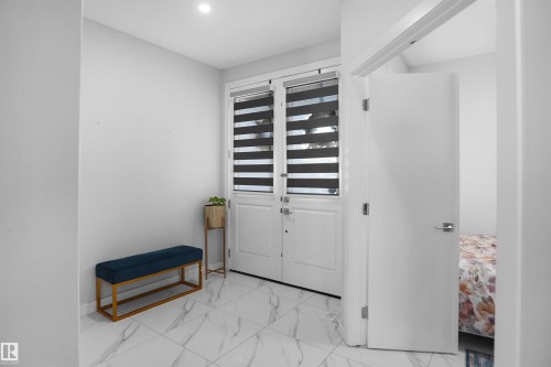 Foyer featuring white tile flooring, recessed lighting, and a white entry door with privacy blinds - 4003 39 Street, Beaumont, AB - Indoor Photo Showing Other Room