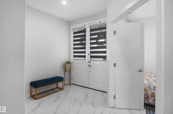 Foyer featuring white tile flooring, recessed lighting, and a white entry door with privacy blinds - 