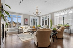 Living area featuring a chandelier, dark wood-style floors, a textured ceiling, and healthy amount of natural light - 