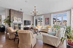 Living room featuring a tile fireplace, dark wood-style flooring, a chandelier, and a textured ceiling - 