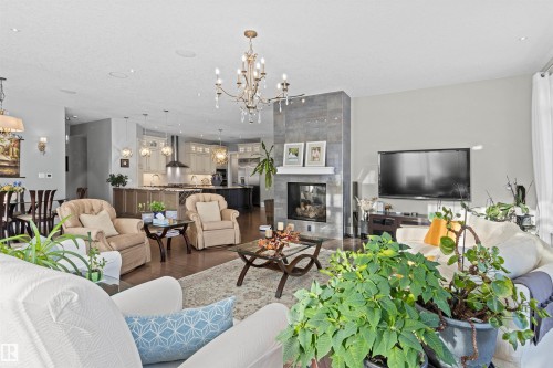Living room featuring dark wood-type flooring, a chandelier, and a tile fireplace - 2796 Wheaton Drive Nw, Edmonton, AB - Indoor Photo Showing Living Room With Fireplace