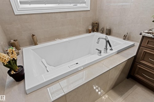 Full bath with a bath, tile walls, vanity, and tile patterned floors - 2796 Wheaton Drive Nw, Edmonton, AB - Indoor Photo Showing Bathroom