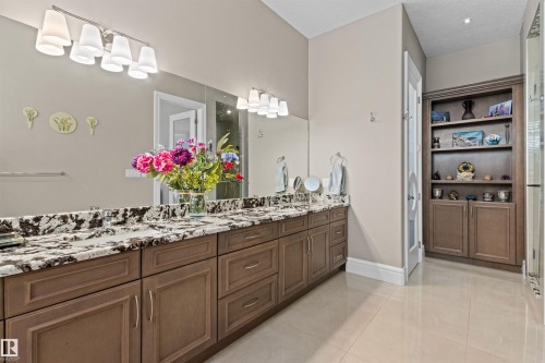 Bathroom with double vanity, light tile patterned floors, and a shower with shower door - 2796 Wheaton Drive Nw, Edmonton, AB - Indoor