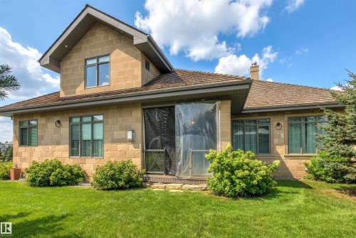 Back of house with a yard, a chimney, and a sunroom - 2796 Wheaton Drive Nw, Edmonton, AB - Outdoor With Facade