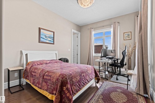 Bedroom with a desk, wood finished floors, and a textured ceiling - 2796 Wheaton Drive Nw, Edmonton, AB - Indoor Photo Showing Bedroom