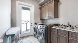 Laundry area with cabinet space, independent washer and dryer, and light tile patterned floors - 