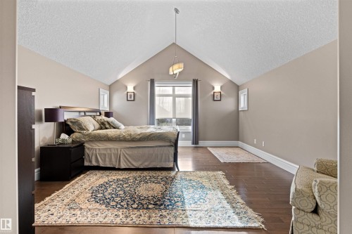 Bedroom with a textured ceiling, dark wood finished floors, and lofted ceiling - 2796 Wheaton Drive Nw, Edmonton, AB - Indoor Photo Showing Bedroom