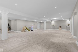 Finished below grade area featuring light colored carpet and recessed lighting - 