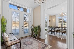 Foyer entrance with a chandelier, a textured ceiling, dark wood finished floors, and french doors - 