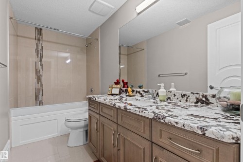 Full bathroom featuring vanity, a textured ceiling, and washtub / shower combination - 2796 Wheaton Drive Nw, Edmonton, AB - Indoor Photo Showing Bathroom