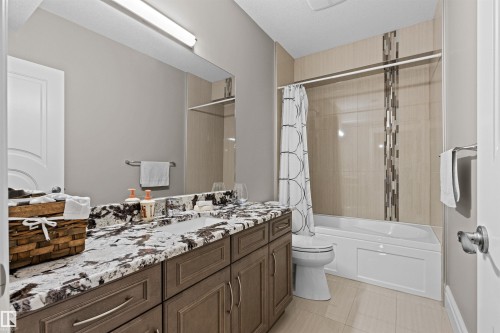 Bathroom featuring vanity, shower / bathtub combination with curtain, and light tile patterned floors - 2796 Wheaton Drive Nw, Edmonton, AB - Indoor Photo Showing Bathroom