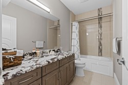 Bathroom featuring vanity, shower / bathtub combination with curtain, and light tile patterned floors - 