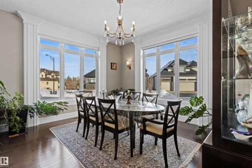Dining space with dark wood-style flooring, a chandelier, and a textured ceiling - 2796 Wheaton Drive Nw, Edmonton, AB - Indoor Photo Showing Dining Room
