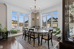 Dining space with dark wood-style flooring, a chandelier, and a textured ceiling - 