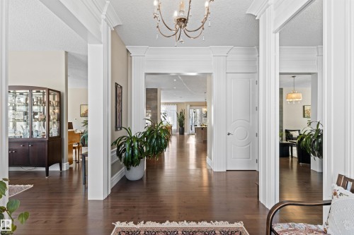 Entrance foyer featuring a chandelier, a textured ceiling, and dark wood finished floors - 2796 Wheaton Drive Nw, Edmonton, AB - Indoor Photo Showing Other Room