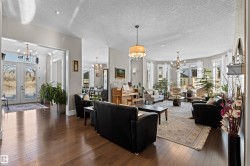Living room featuring dark wood-style flooring, a chandelier, french doors, and a textured ceiling - 