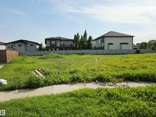 Expansive undeveloped lot featuring a concrete sidewalk at the property boundary and established fencing along the rear - 4178 Cameron Heights Point(E) Nw, Edmonton, AB 