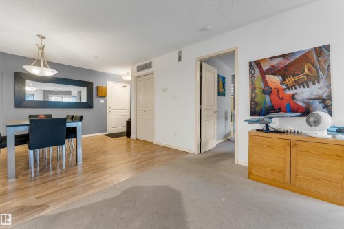 Open-concept living area featuring wood-finish flooring extending into the dining space - #136 16035 132 St Nw, Edmonton, AB - Indoor Photo Showing Dining Room