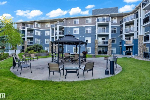 Communal outdoor patio featuring a metal gazebo, surrounding seating, and a concrete surface - #136 16035 132 St Nw, Edmonton, AB - Outdoor With Balcony