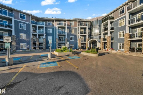 Multi-story residential building featuring a stone and siding exterior - #136 16035 132 St Nw, Edmonton, AB - Outdoor With Balcony With Facade