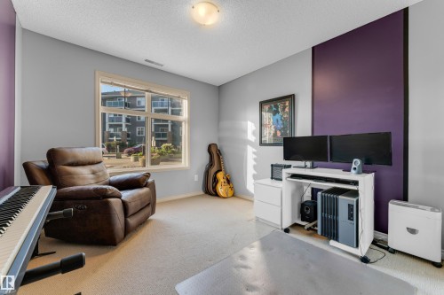 Carpeted room with a large window and a ceiling-mounted light fixture - #136 16035 132 St Nw, Edmonton, AB - Indoor