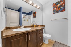 Bathroom featuring a dark wood-finish vanity with an integrated sink, a light-colored countertop, a chrome faucet, and a large wall mirror - 