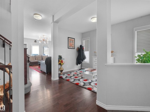 Hardwood-style flooring throughout, with light gray walls and white baseboards - 1716 60 Street Sw, Edmonton, AB - Indoor Photo Showing Other Room