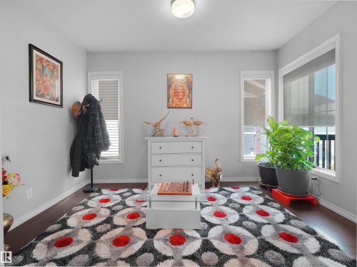 Bright interior space featuring dark wood-finish flooring, light grey walls, and white trim - 1716 60 Street Sw, Edmonton, AB - Indoor