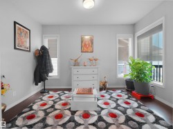 Bright interior space featuring dark wood-finish flooring, light grey walls, and white trim - 