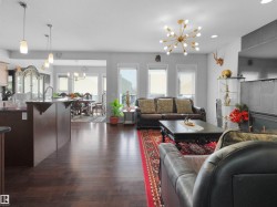 Open-concept living space with dark wood-finish flooring - 
