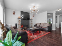 Expansive living area featuring rich wood-finish flooring and a contemporary sputnik-style chandelier - 