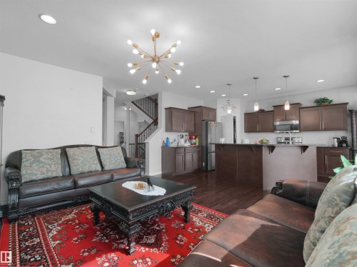 Open-concept living area featuring wood-finish flooring, recessed lighting, and a modern sputnik chandelier - 1716 60 Street Sw, Edmonton, AB - Indoor Photo Showing Living Room