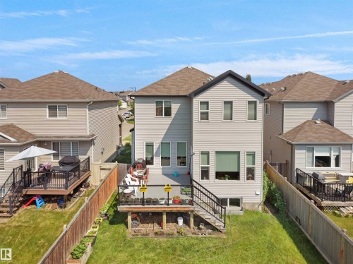 Rear exterior featuring light-colored siding and a multi-level deck with black railings - 1716 60 Street Sw, Edmonton, AB - Outdoor With Deck Patio Veranda With Exterior