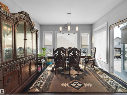 Spacious dining room featuring a dark wood-finish floor and multiple large windows - 1716 60 Street Sw, Edmonton, AB - Indoor Photo Showing Dining Room