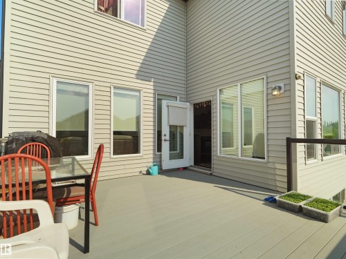 Spacious outdoor deck featuring composite decking, a clear railing system, multiple windows, and exterior siding - 1716 60 Street Sw, Edmonton, AB - Outdoor With Exterior