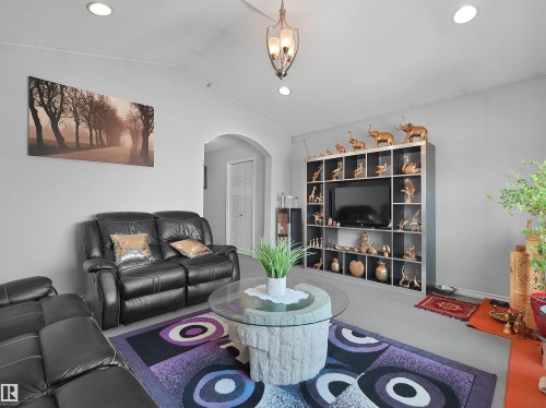 Recessed lighting illuminating the ceiling, arched doorway, and built-in shelving unit - 1716 60 Street Sw, Edmonton, AB - Indoor Photo Showing Living Room