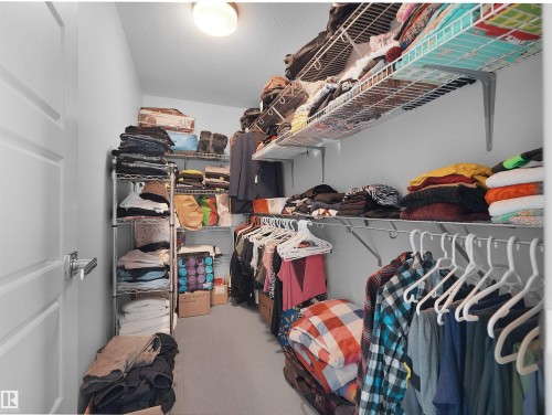 Walk-in closet featuring built-in wire shelving, hanging rods, and recessed lighting - 1716 60 Street Sw, Edmonton, AB - Indoor With Storage