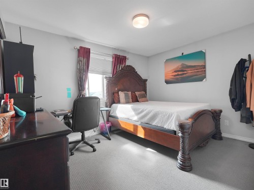 Carpeted room with a single window featuring blinds and decorative drapes - 1716 60 Street Sw, Edmonton, AB - Indoor Photo Showing Bedroom