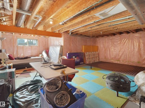 Unfinished basement space featuring exposed wood joists and subflooring, insulated walls, and visible ductwork - 1716 60 Street Sw, Edmonton, AB - Indoor Photo Showing Basement