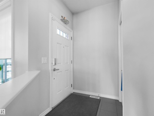 Front entry featuring a white paneled door with glass inserts, brushed nickel hardware, and tile flooring - 1716 60 Street Sw, Edmonton, AB - Indoor Photo Showing Other Room