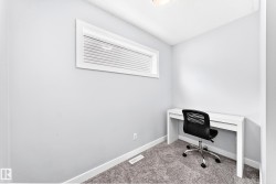 Compact room featuring neutral gray walls and gray carpeting - 