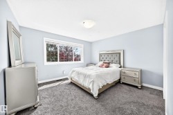Light blue walls complement the gray carpeting in this bedroom - 