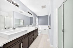 Double vanity with rectangular vessel sinks, dark wood-finish cabinetry, and a full-width mirror - 