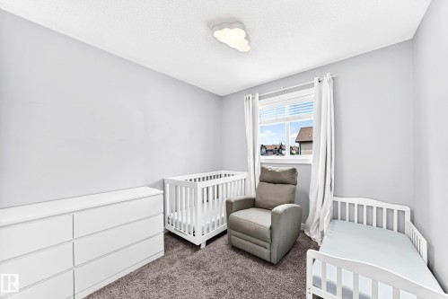 Soft gray wall paint with textured ceiling, featuring a window with white blinds and curtains, and plush gray carpeting - 17508 58 Street Nw, Edmonton, AB - Indoor Photo Showing Bedroom