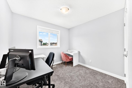 Bright room featuring a window with white trim, light gray walls, and textured carpet flooring - 17508 58 Street Nw, Edmonton, AB - Indoor Photo Showing Office