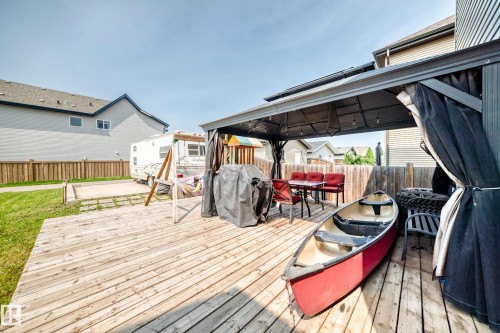 Expansive wooden deck featuring a covered gazebo with string lighting, ample space for outdoor dining, and a wooden privacy fence - 17508 58 Street Nw, Edmonton, AB - Outdoor With Deck Patio Veranda With Exterior