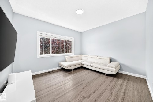 Room featuring wood-finish flooring, light blue walls, and white baseboards - 17508 58 Street Nw, Edmonton, AB - Indoor Photo Showing Other Room