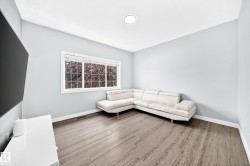 Room featuring wood-finish flooring, light blue walls, and white baseboards - 