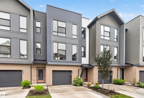 Modern townhome facade featuring multi-tone siding, large windows, and an integrated garage - #84 1304 Rutherford Rd Sw, Edmonton, AB - Outdoor With Facade
