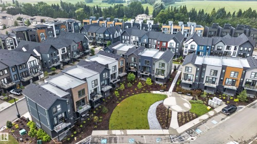 Modern townhome community featuring diverse architectural styles and a central landscaped green space - #84 1304 Rutherford Rd Sw, Edmonton, AB - Outdoor